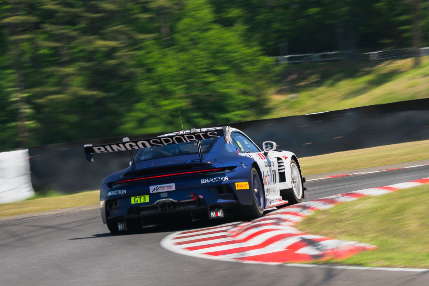 The #9 Lollipop-liveried Porsche 911 GT3 R through a corner at Sugo